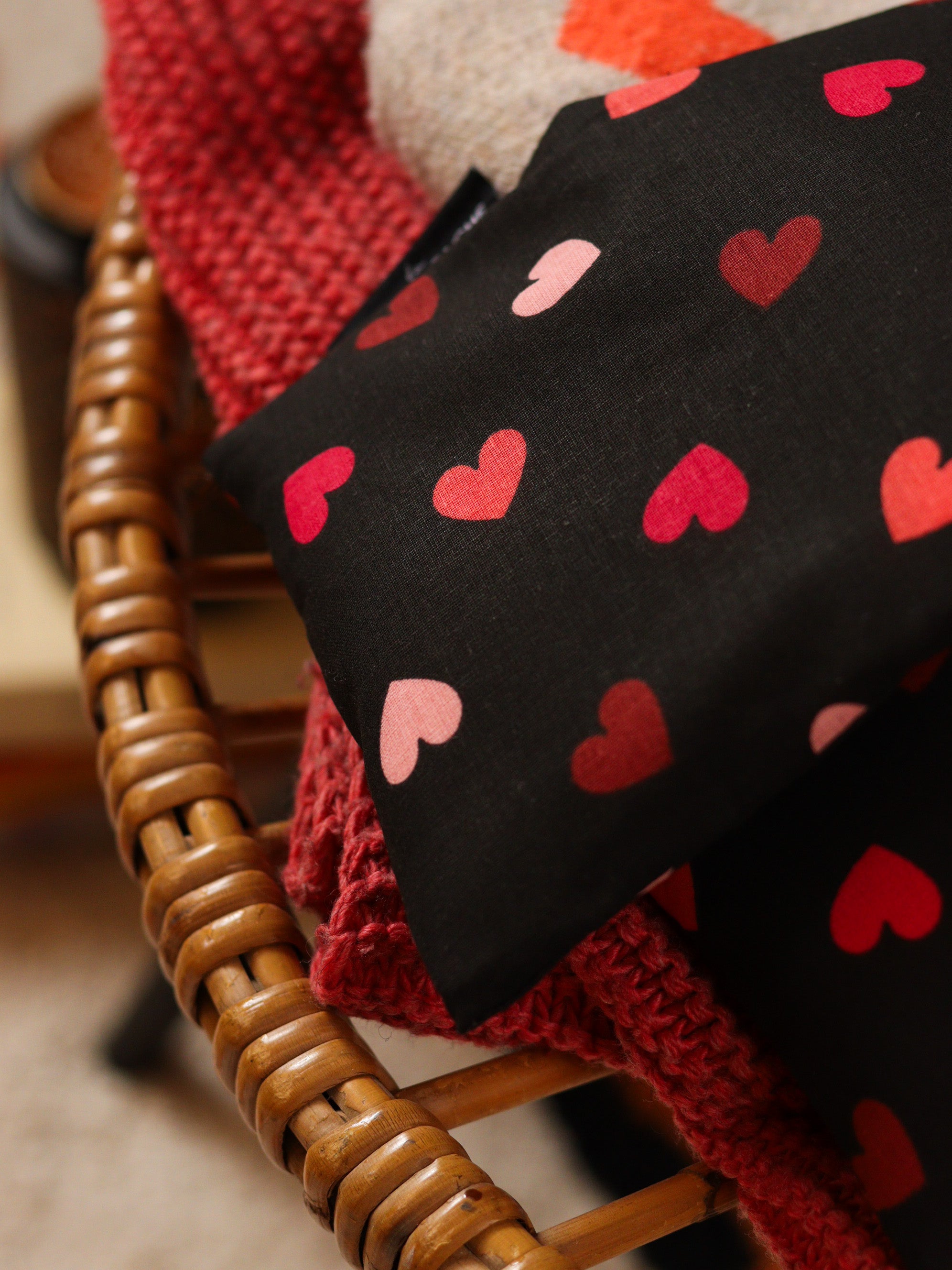 détail bouillotte longue aux graines de lin bio pour se détendre, apaiser l'esprit et réduire l'anxiété, joli tissu noir avec des cœurs, fabrication française