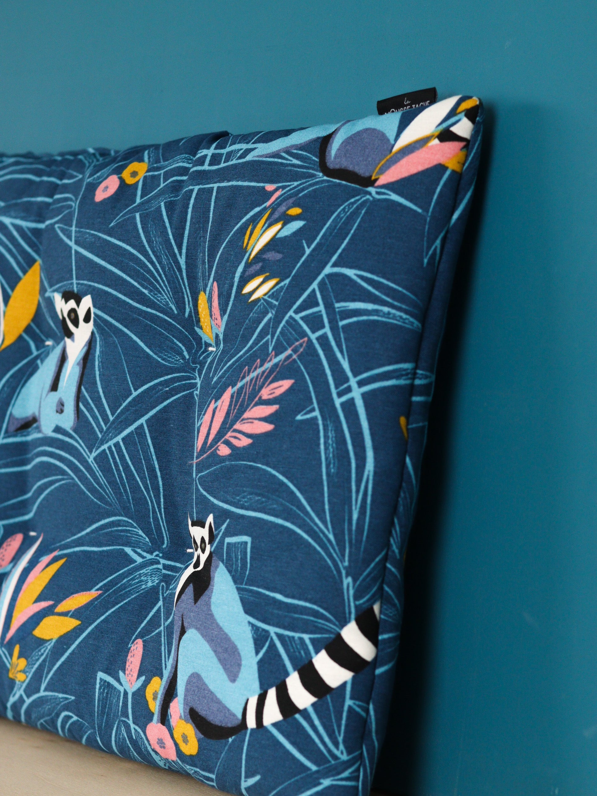 détail coussin d’entrée personnalisé, tissu coloré jungle avec lémuriens, meuble IKEA molger bois clair