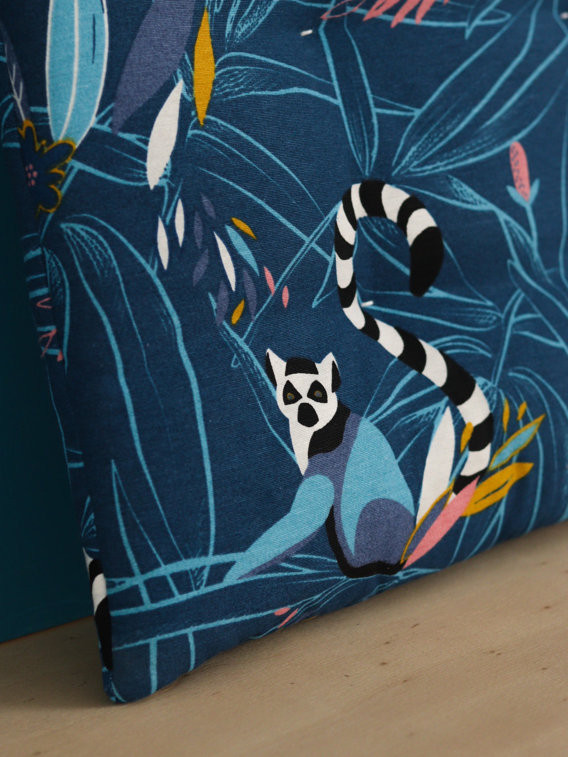 détail coussin d’entrée personnalisé capitonné, tissu coloré jungle avec lémuriens, meuble IKEA molger bois clair