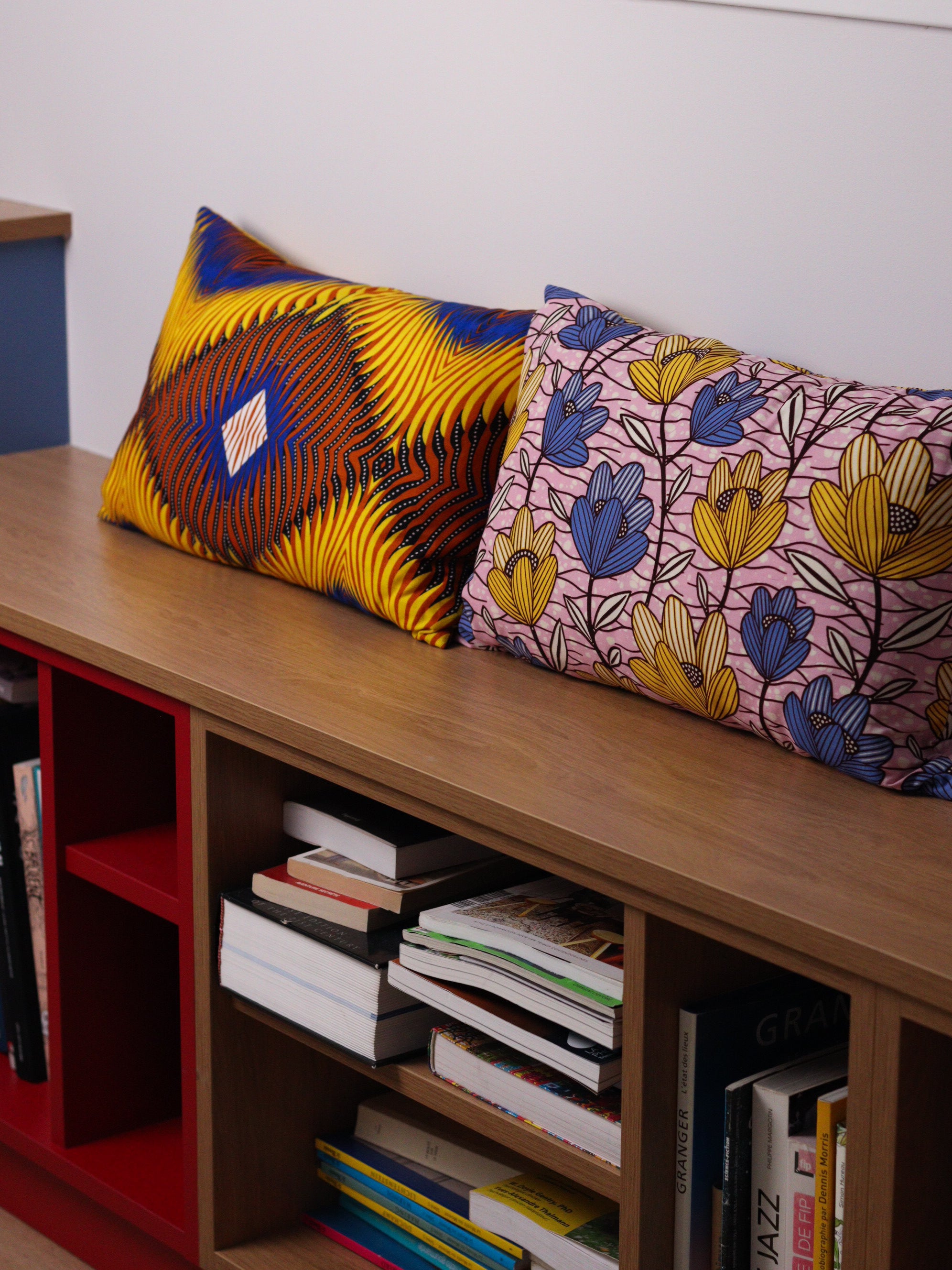 coussin colorés cousus sur-mesure, posés sur une banquette