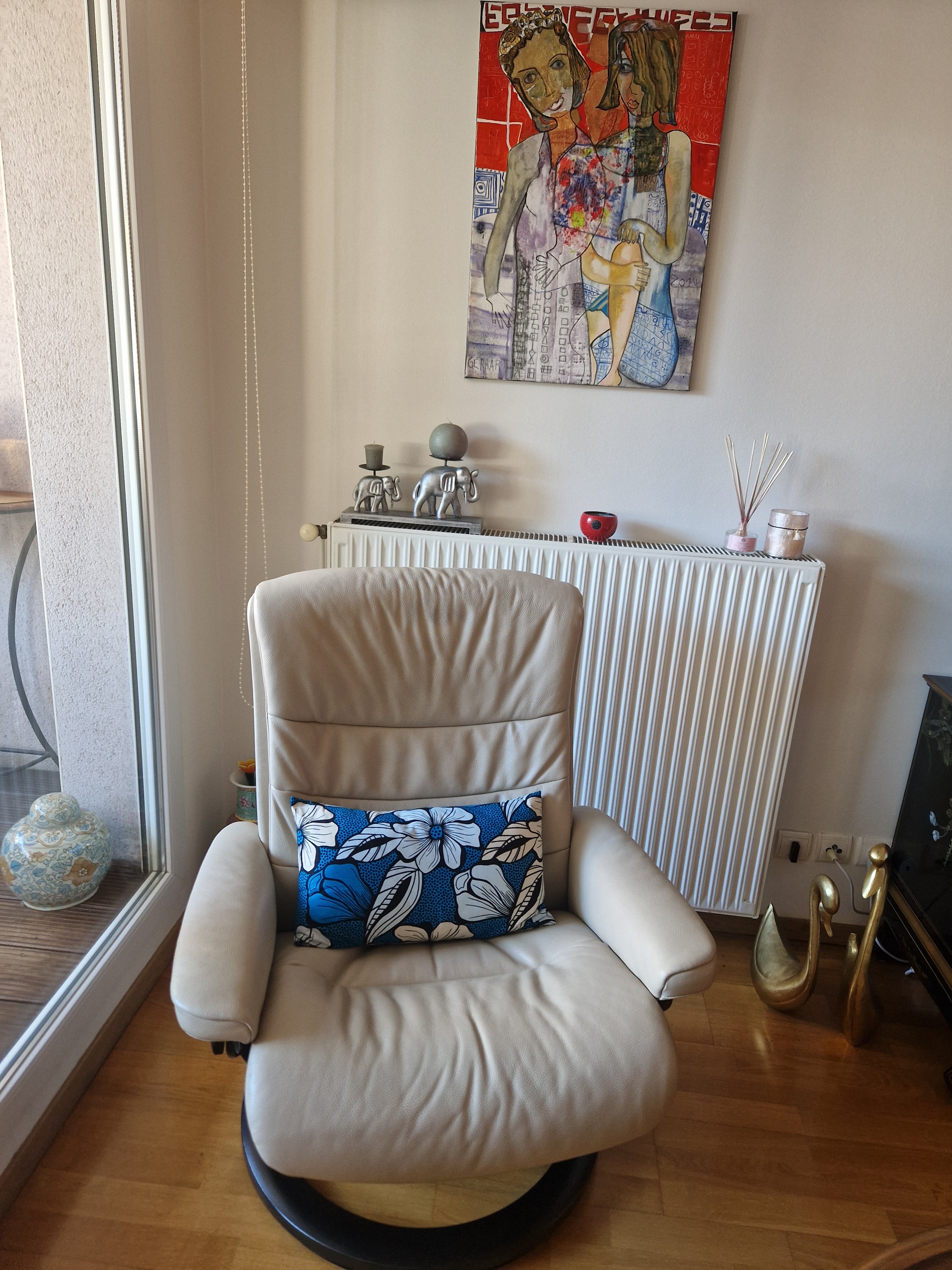 Mise en scène de coussins en wax bleu et rouge dans un salon.