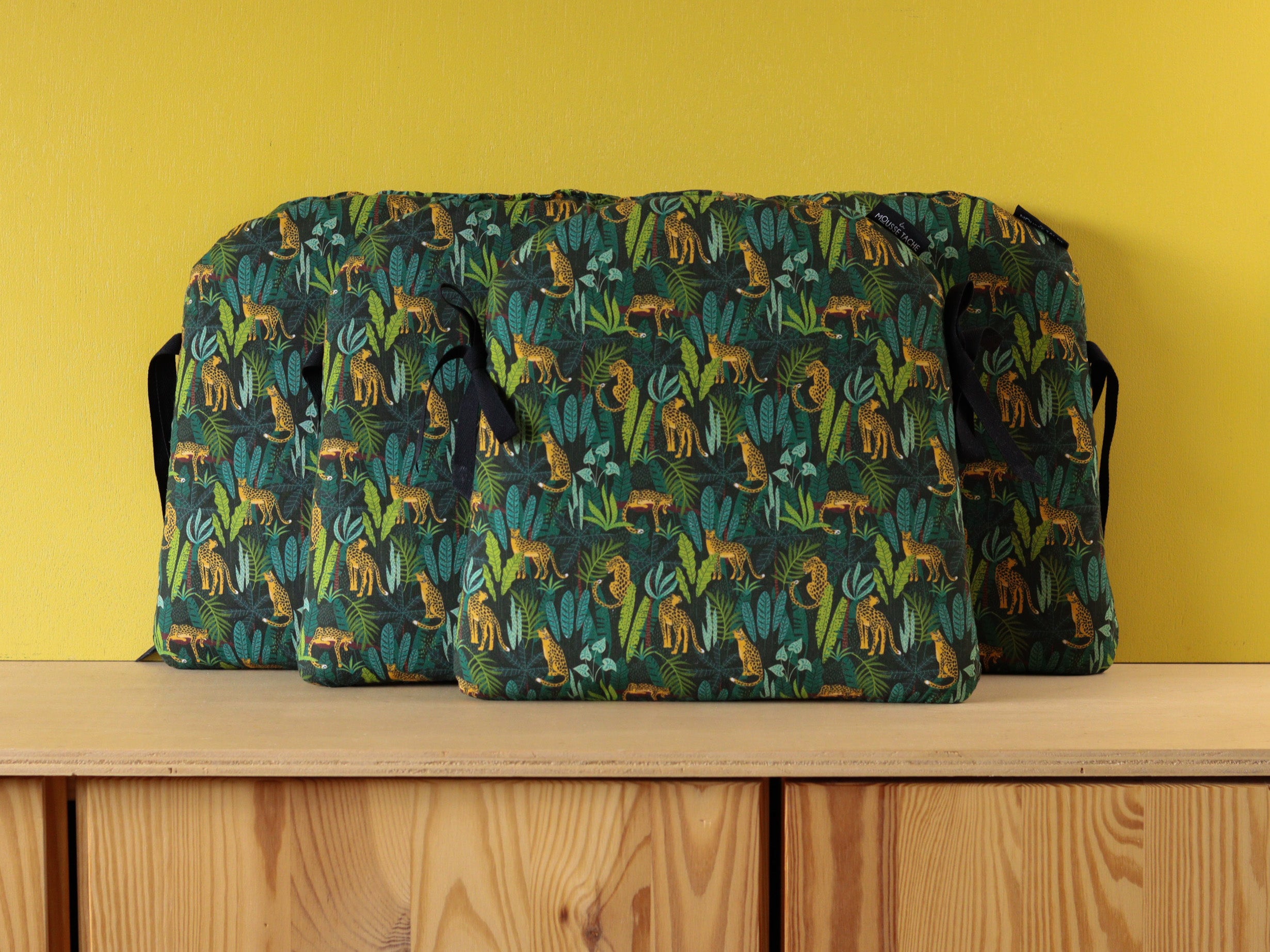 Galettes de chaise artisanales adaptées à une chaise Tolix, tissu vert jungle et léopards