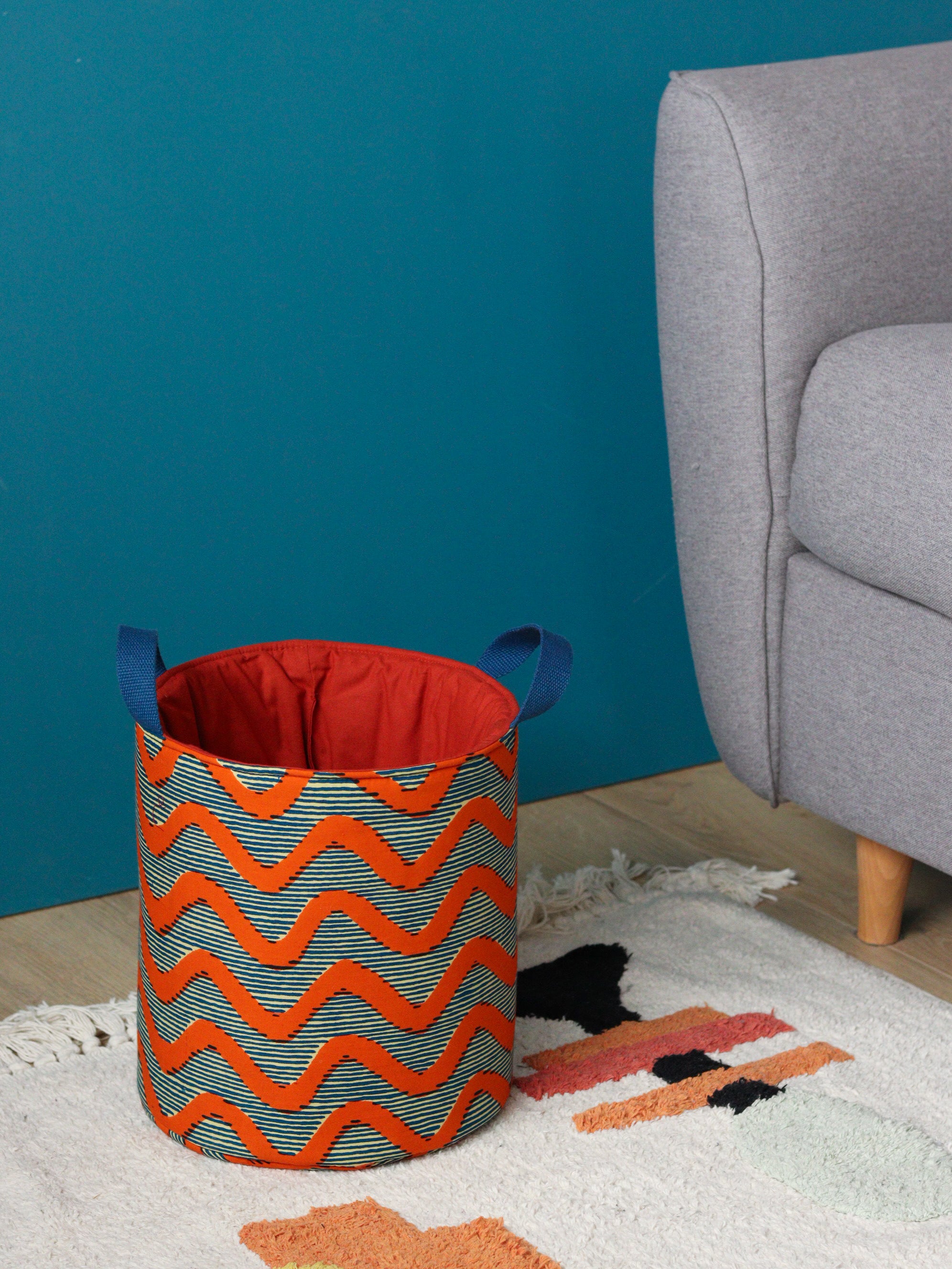Panier déco L wax africain chevrons orange vif sur fond bleu crème, posé salon canapé