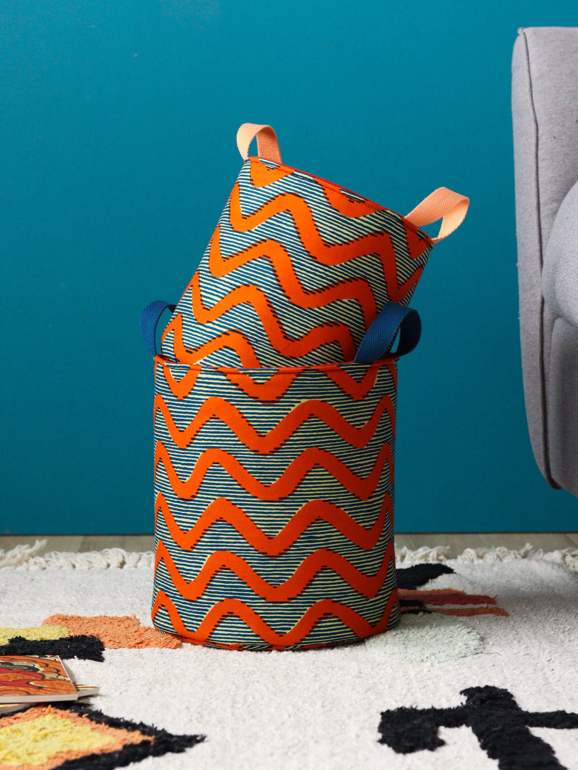 Panier rond wax bleu et orange utilisé comme rangement chambre