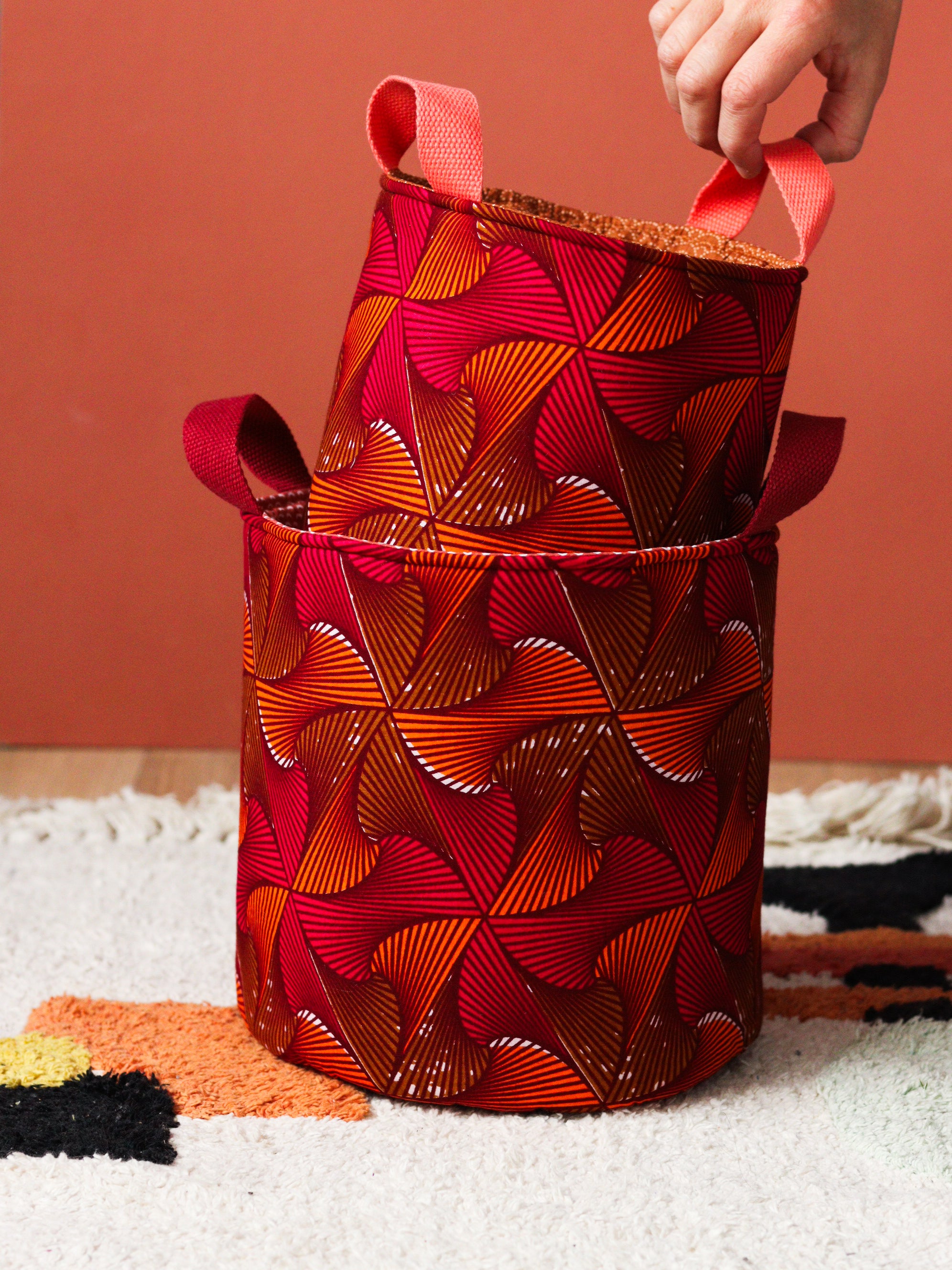 Paniers wax africain orange rose posés dans un salon coloré