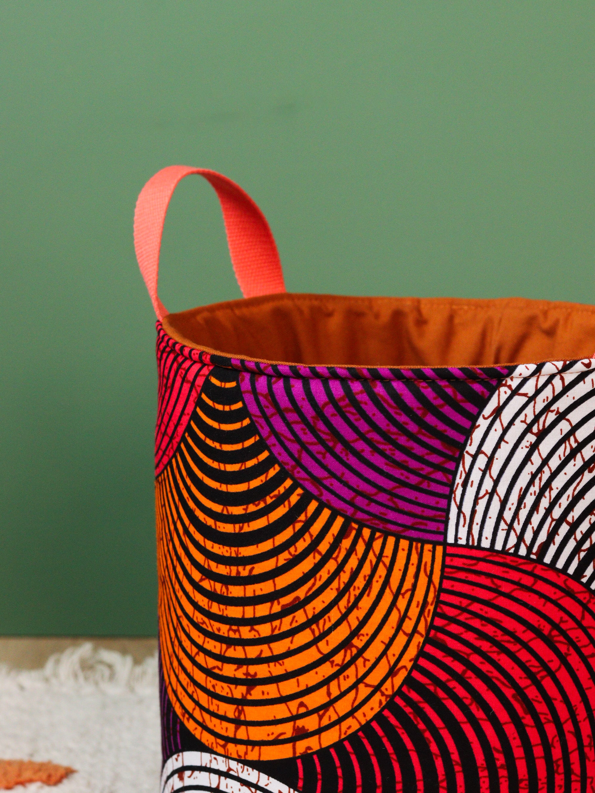 Grand panier rangement wax africain orange L posé au sol, décoration salon"