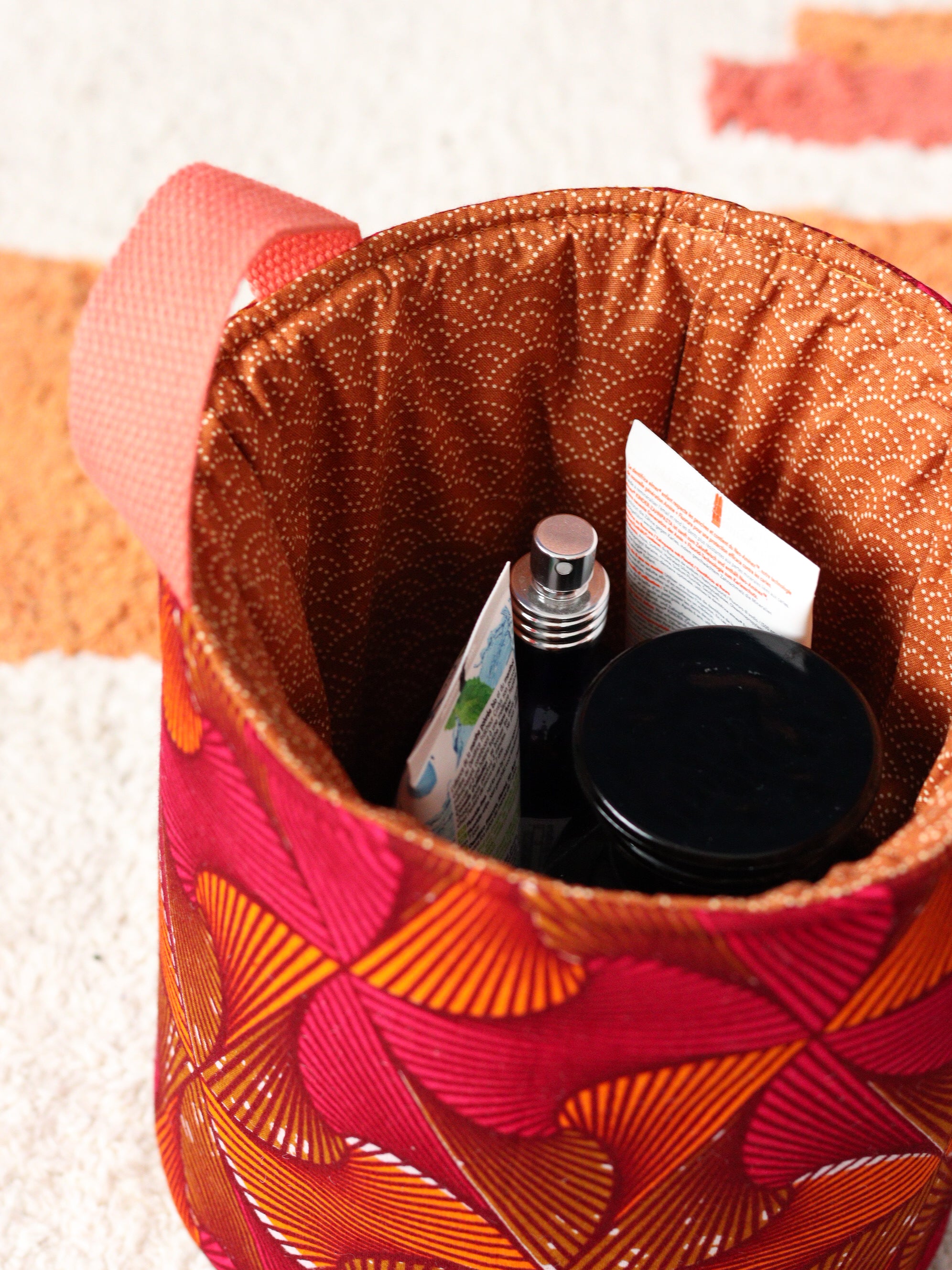 Détail panier wax africain Chéri ne me tourne pas le dos, tons orange et rose, rangement salle de bain