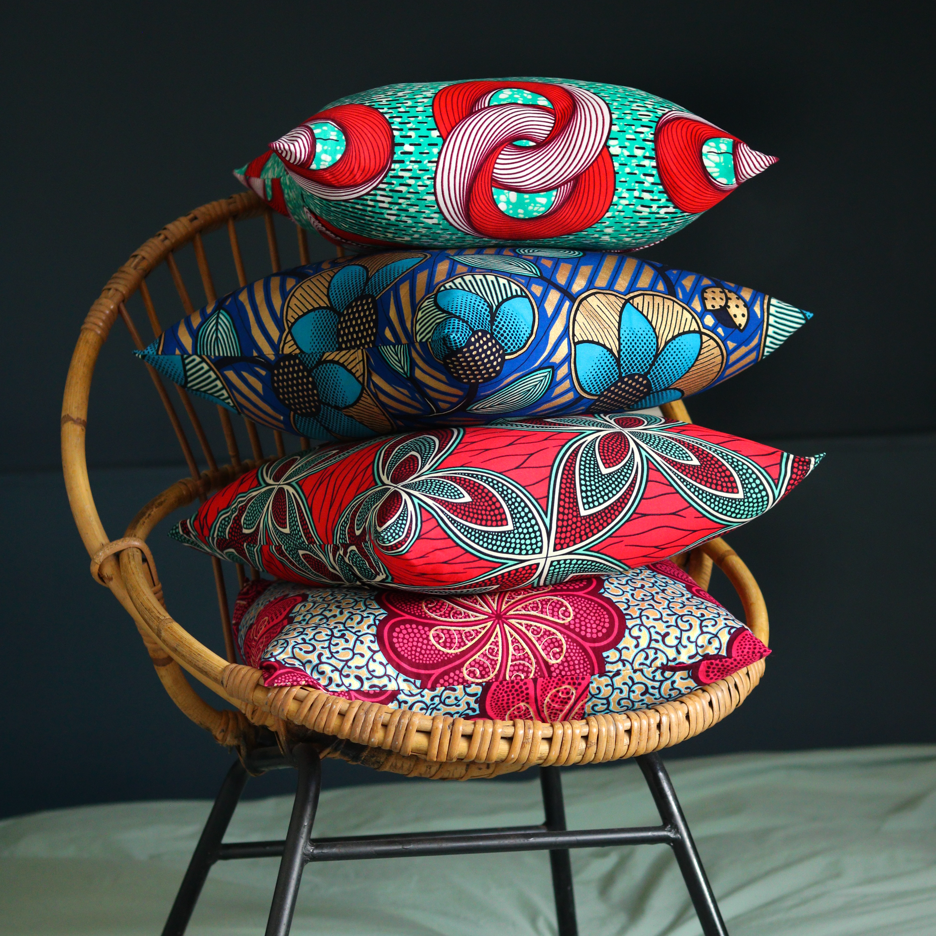 Coussin wax sur fauteuil rotin pièce noire