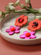 Boucles d’oreilles deux fleurs en cuir orange et rose et tissu wax, fabrication artisanale, couleurs pop