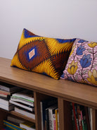 coussin tissu du sri lanka, motif abstrait jaune ocre bleu, posé sur banquette