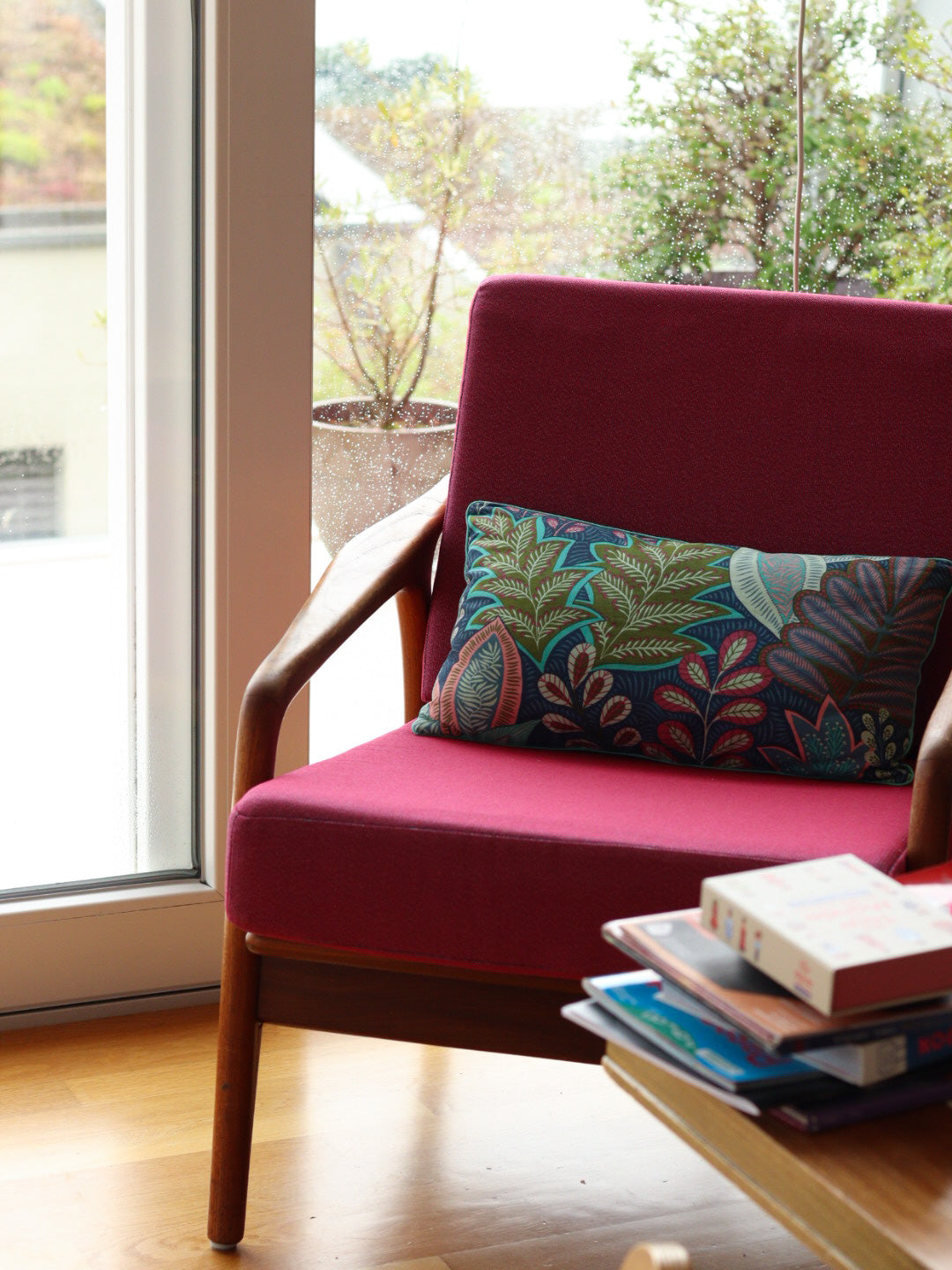 coussins personnalisés bleu avec motif végétal et passepoil coloré, fauteuil vintage bois et tissu rose framboise