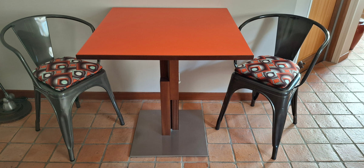Aménagement intérieur personnalisé avec des chaises industrielles Tolix A habillées de coussins en wax colorés et moelleux.