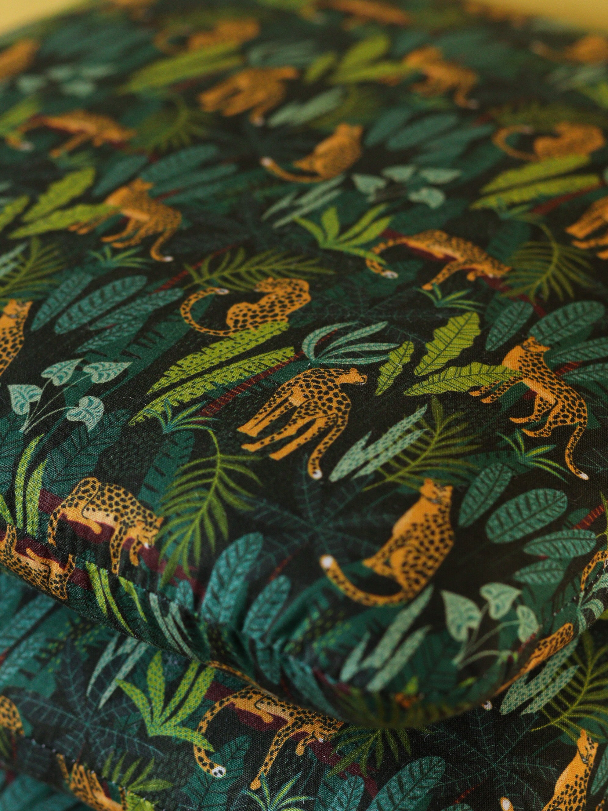 détail d'une galette de chaise artisanale adaptée à une chaise Tolix, tissu vert jungle