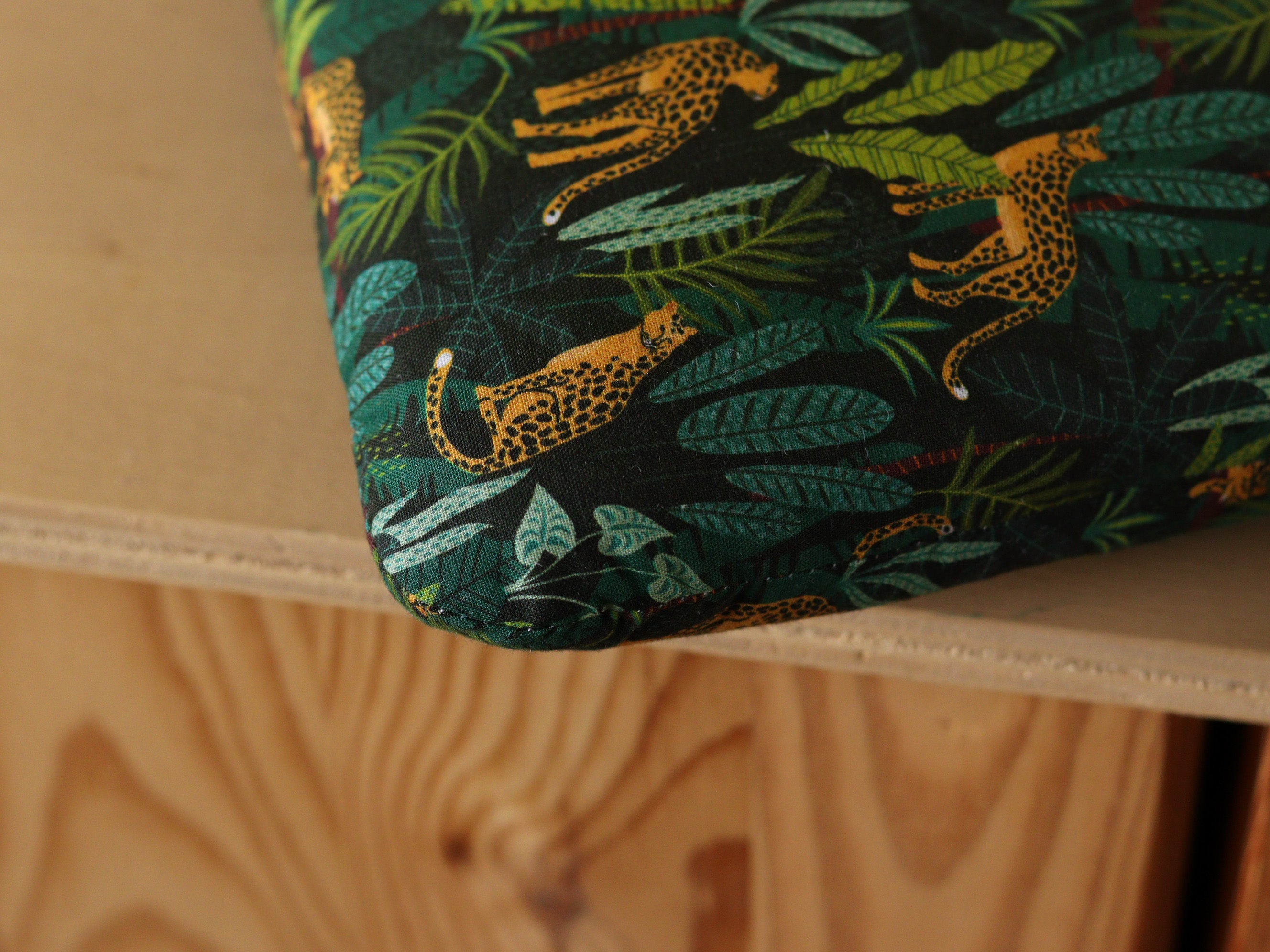 Détail d'une galette de chaise Tolix sur mesure avec liens en tissu jungle vert avec motifs léopards, cousue artisanalement en France