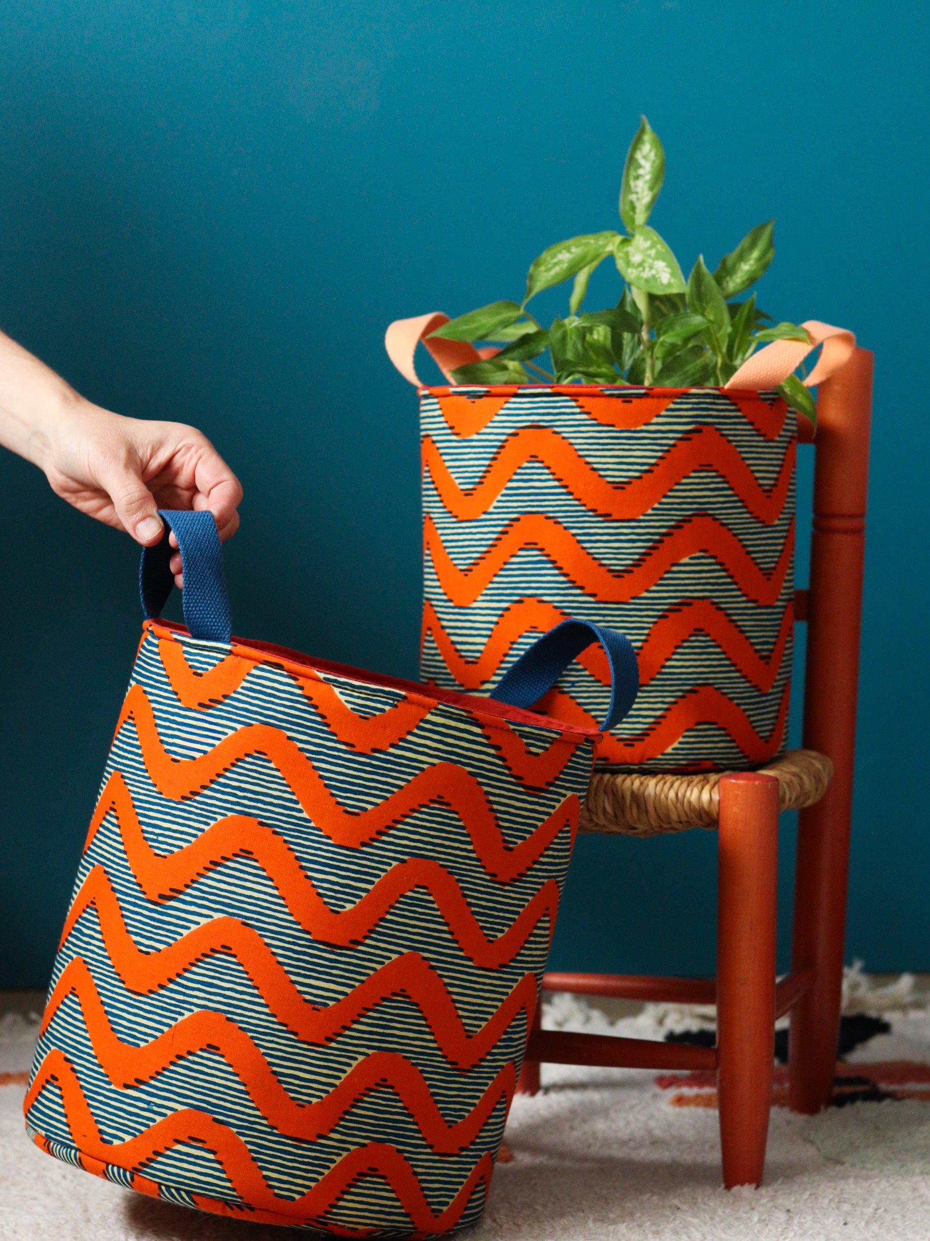 Deux paniers Gága en tissu africain wax orange et bleu, taille S et L, fond bleu canard
