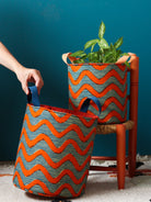 Panier déco coloré en wax africain motif zigzag orange, utilisé en cache-pot avec plante verte