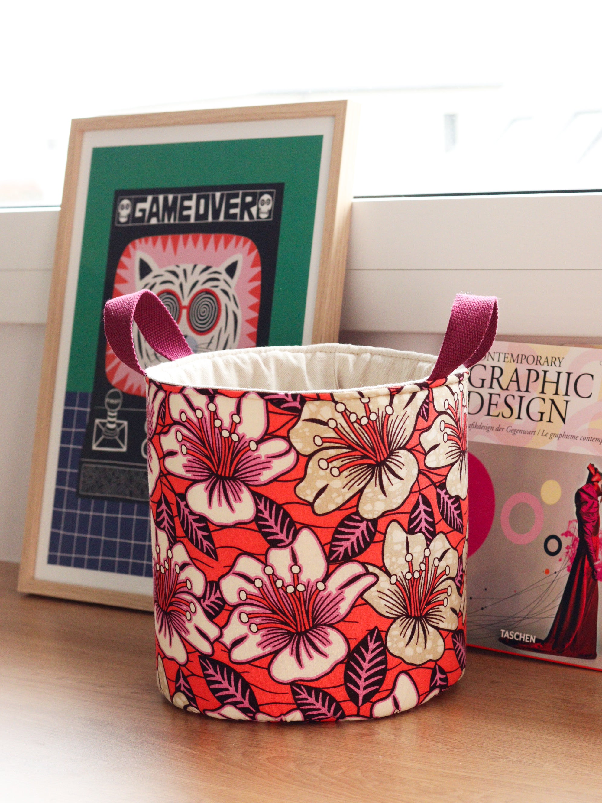 Panier déco M wax orange hibiscus posé dans un intérieur, décoration colorée