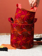 Paniers wax africain orange rose posés dans un salon coloré