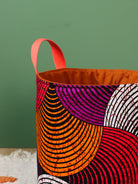 Grand panier rangement wax africain orange L posé au sol, décoration salon"